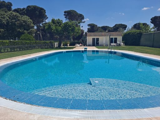 Piscina rehabilitada Aqbierta con escalera curva.