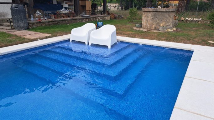 Piscina Aqbierta con escaleras y solarium.